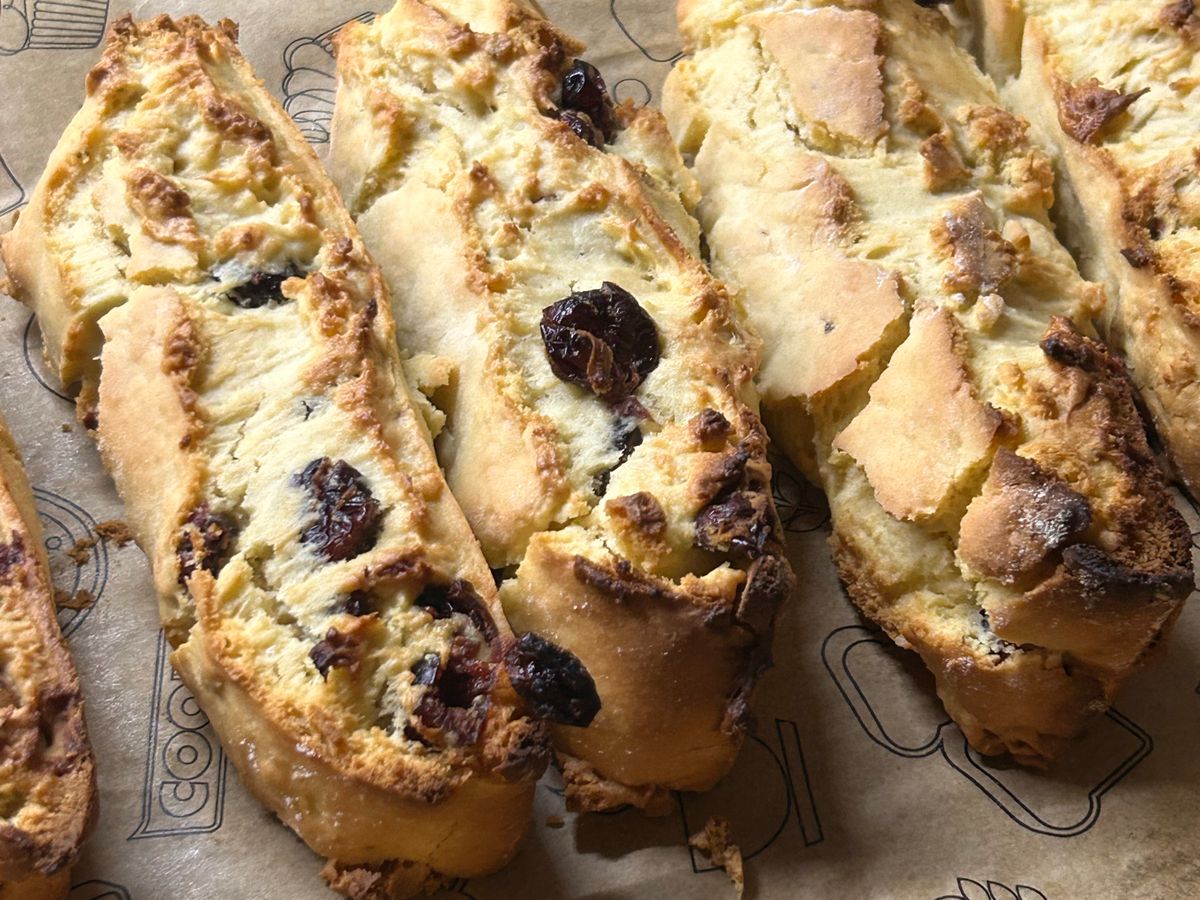 Biscotti with dried cranberries laid out on baking paper, close up