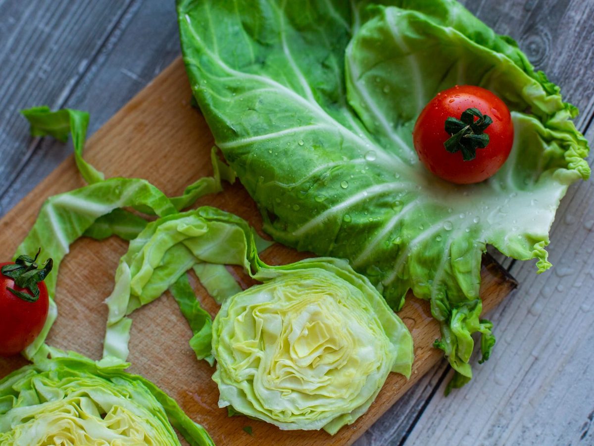 Cut white cabbage and cherry tomatoes on a wooden board