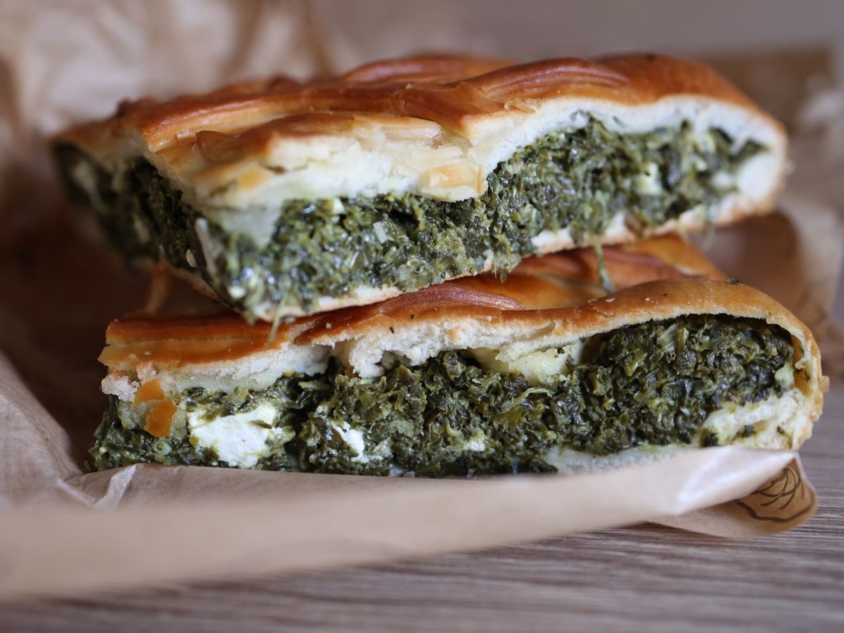 Two slices of spinach and feta pie on parchment