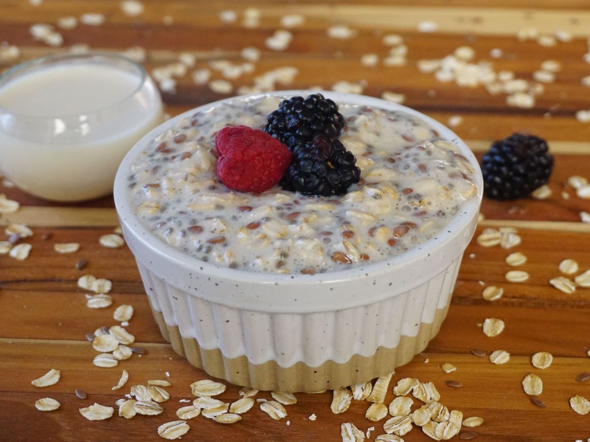 Overnight oats with raspberries and blackberries and a small jug of milk
